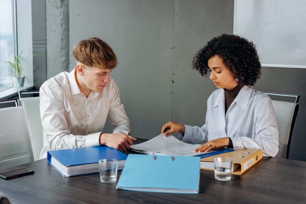 Two colleagues discussing important business documents at an office desk.